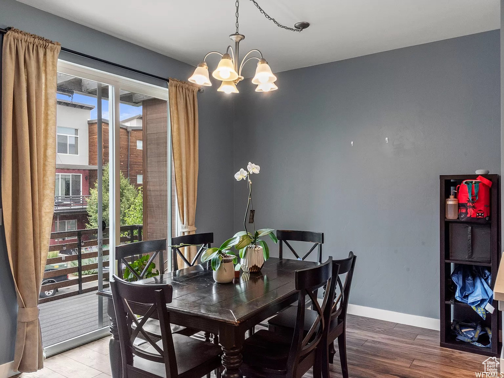 Dining room featuring a chandelier, baseboards, and wood finished floors