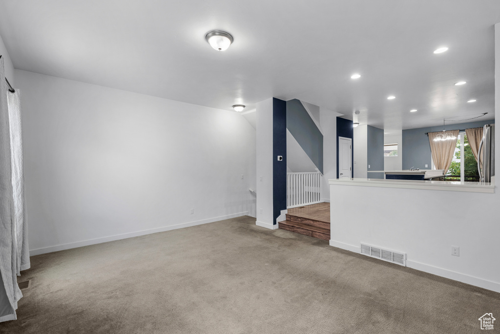 Unfurnished living room featuring carpet floors and recessed lighting