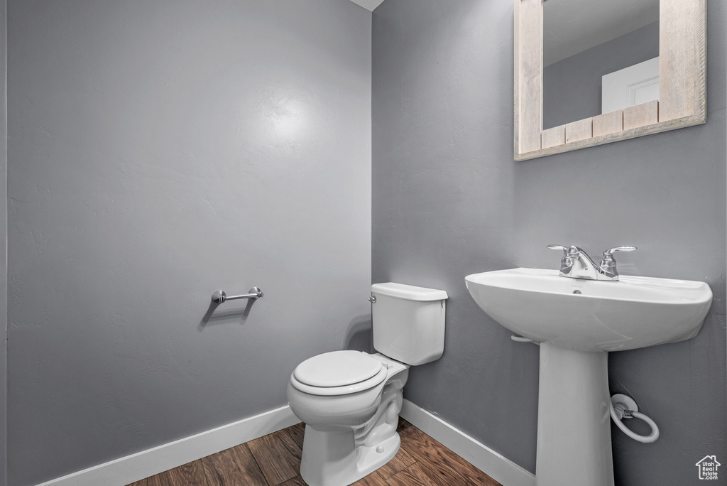 Half bath featuring wood finished floors and toilet