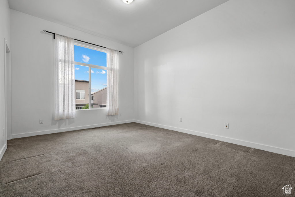 Carpeted empty room featuring baseboards