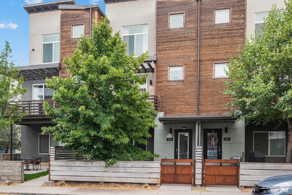 View of front of home featuring a gate, stucco siding, and a fenced front yard