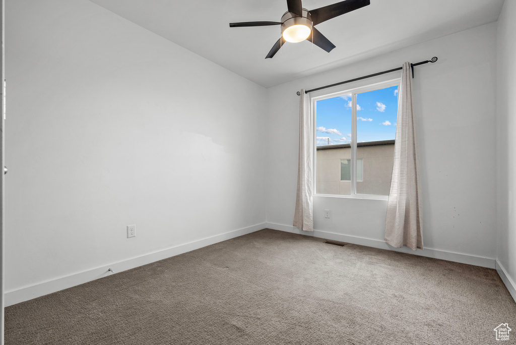 Unfurnished room featuring carpet floors and ceiling fan