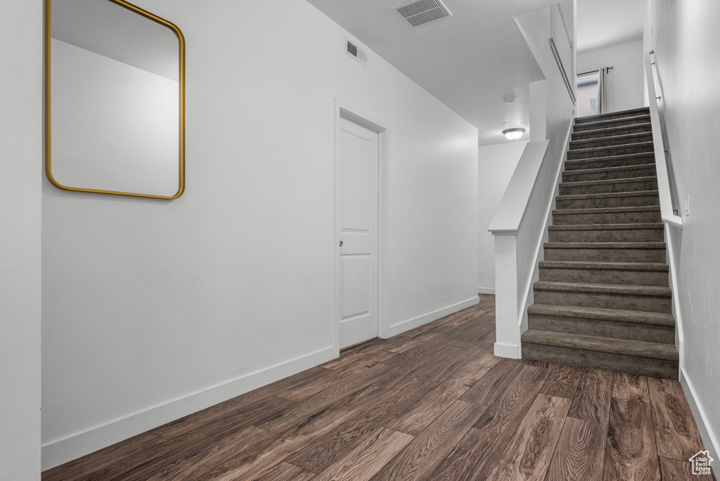 Staircase featuring wood finished floors and baseboards