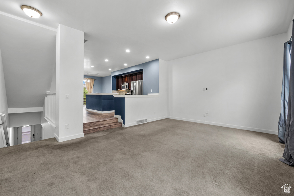 Unfurnished living room featuring carpet floors and recessed lighting