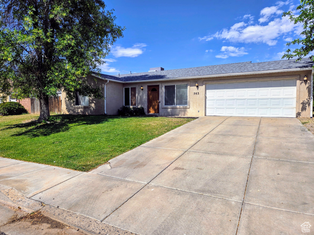 Single story home with driveway, a front lawn, a garage, and stucco siding