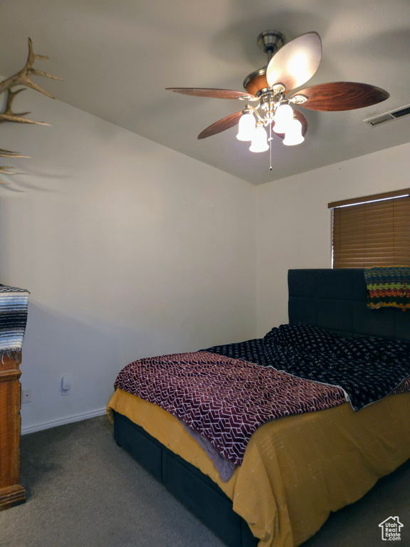 Carpeted bedroom with a ceiling fan