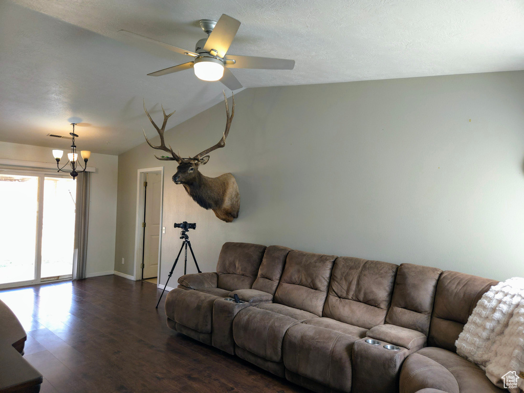 Living area with dark wood-type flooring, a chandelier, baseboards, and a ceiling fan