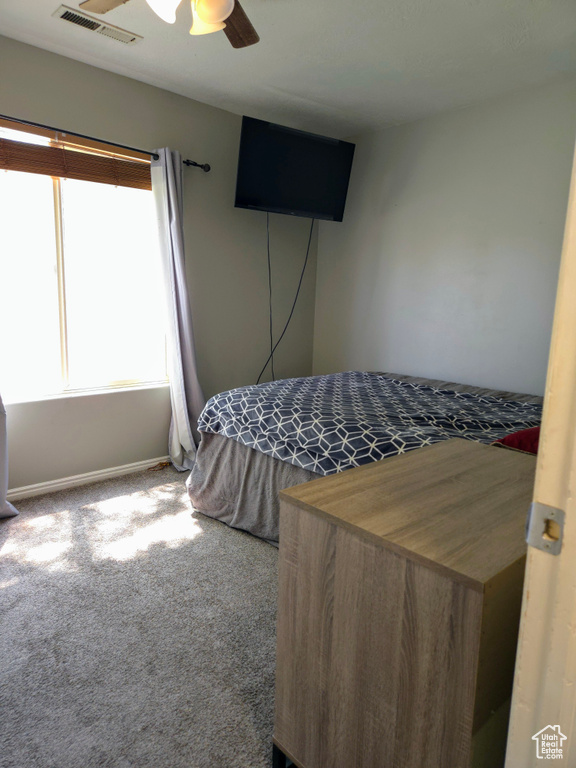 Bedroom with carpet, baseboards, and a ceiling fan