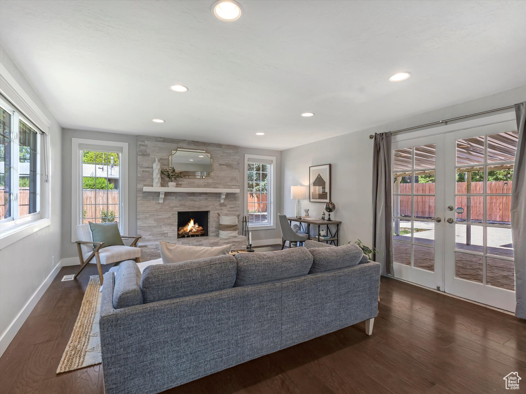Living room featuring french doors, a fireplace, baseboards, dark wood finished floors, and recessed lighting