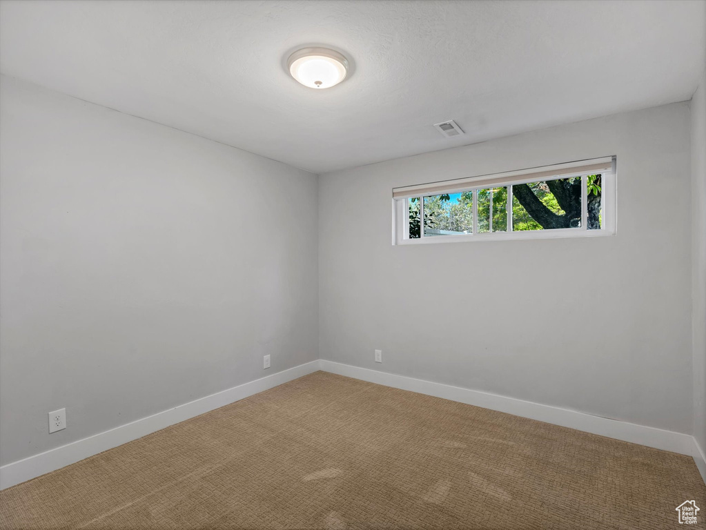 Empty room with light carpet and baseboards