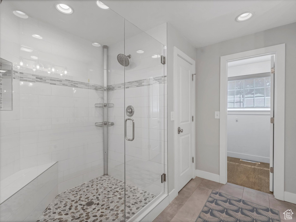 Full bath featuring a shower stall, recessed lighting, tile patterned flooring, and baseboards