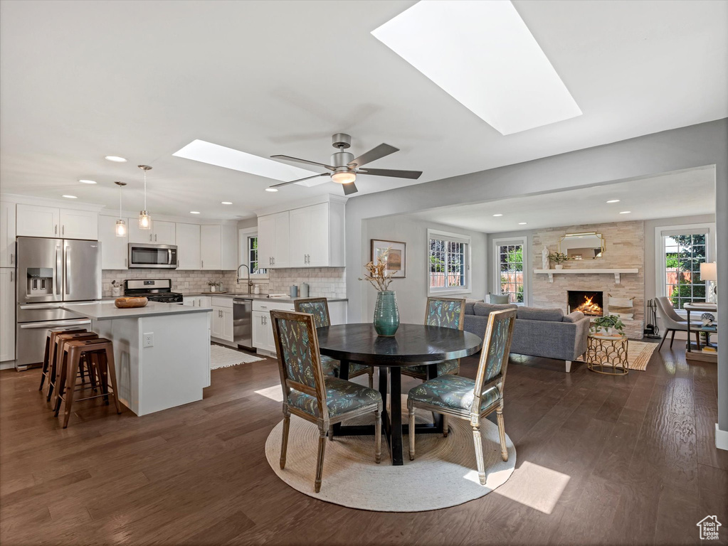 Dining space featuring a skylight, healthy amount of natural light, dark wood-style floors, and recessed lighting