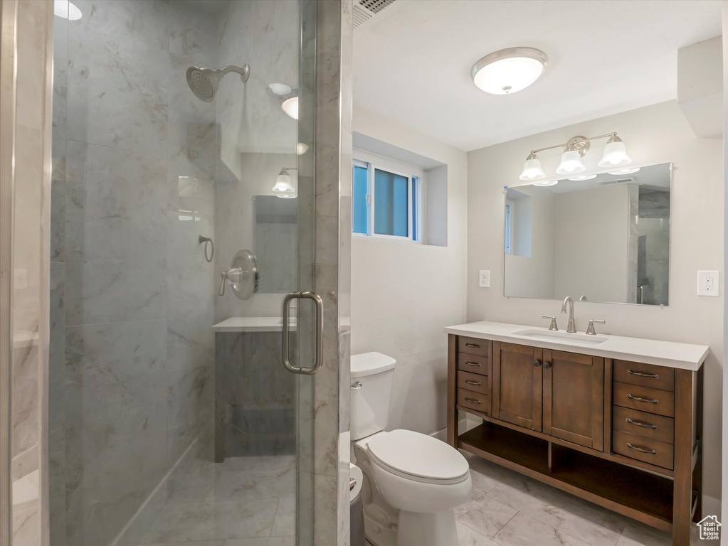 Full bathroom featuring a shower stall, vanity, and toilet