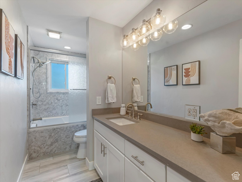 Full bath featuring a combined bath / shower with marble appearance, vanity, toilet, baseboards, and recessed lighting