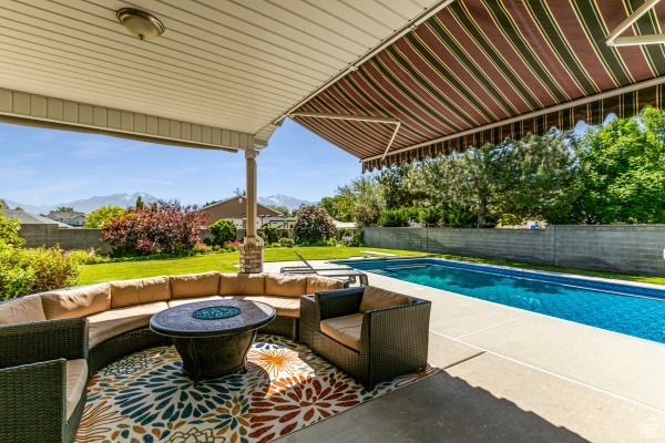 View of swimming pool featuring an outdoor living space with a fire pit and a patio