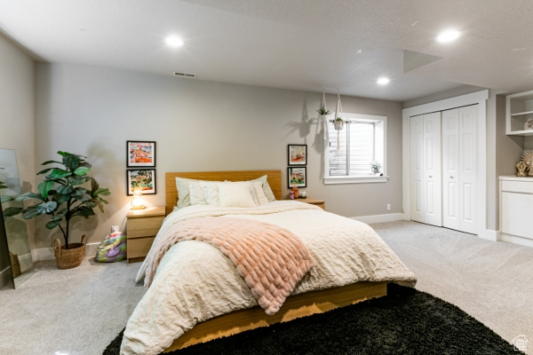 Carpeted bedroom with baseboards, recessed lighting, and a closet