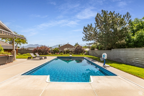 View of pool with a patio, a fenced backyard, and a mountain view
