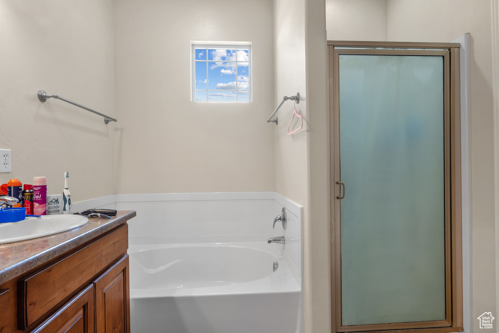 Full bathroom with vanity, a garden tub, and a stall shower