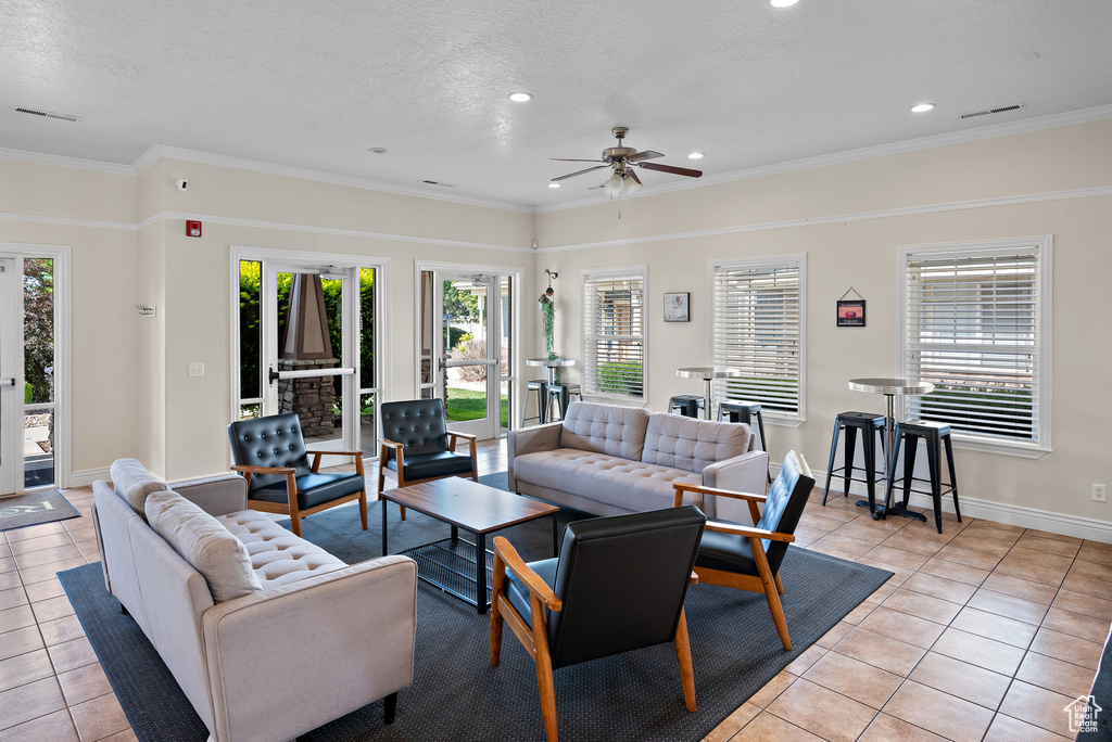 Living room featuring light tile patterned floors, ceiling fan, recessed lighting, crown molding, and baseboards