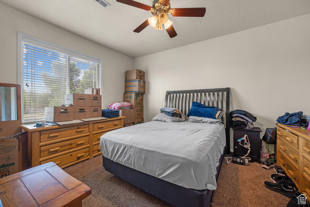Bedroom featuring dark carpet and a ceiling fan