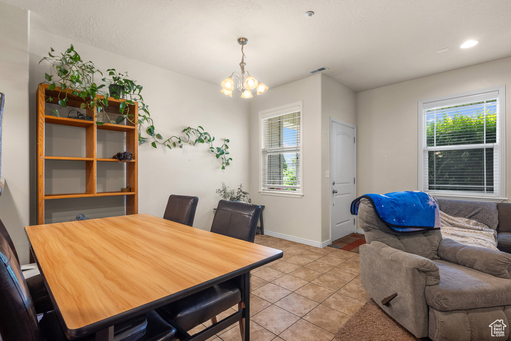 Dining area featuring a chandelier, light tile patterned floors, baseboards, and recessed lighting