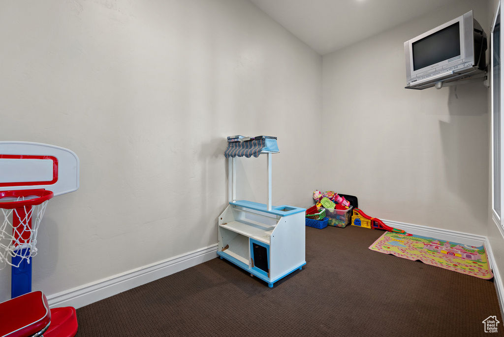 Game room with dark carpet and baseboards
