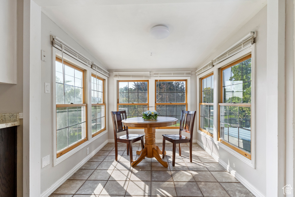 Sunroom / solarium featuring healthy amount of natural light, vaulted ceiling, and baseboards