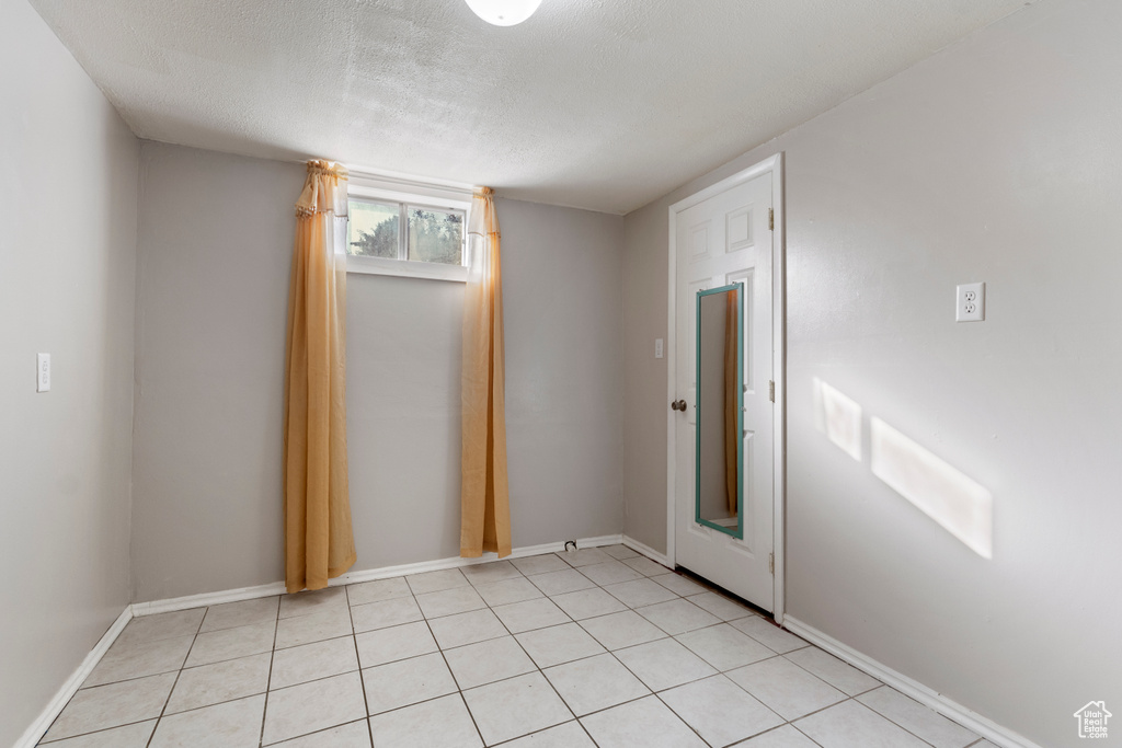 Spare room featuring a textured ceiling and baseboards