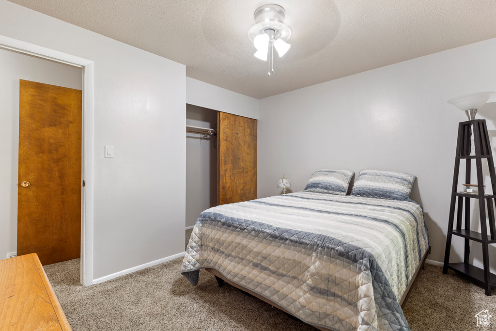 Carpeted bedroom featuring a closet, baseboards, and ceiling fan