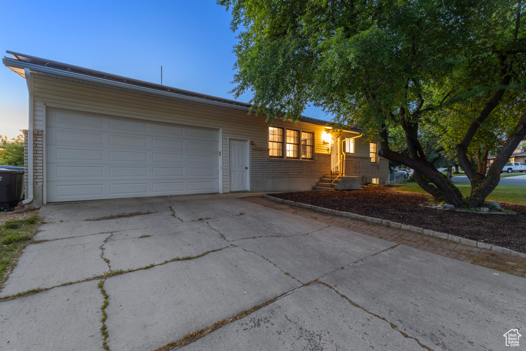 Ranch-style house with driveway, a garage, and brick siding