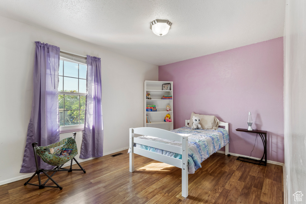 Bedroom with wood finished floors and baseboards
