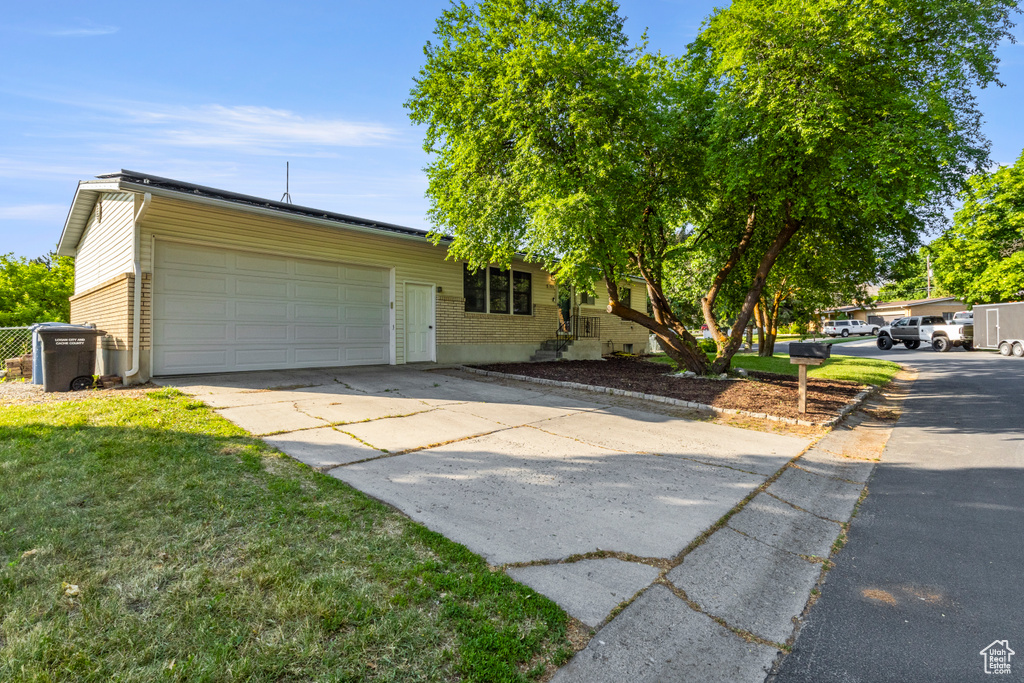 View of front of home with a garage, driveway, and a front yard