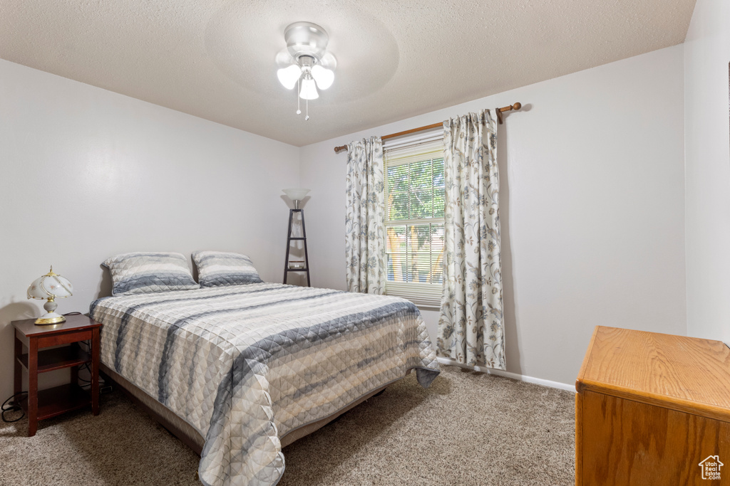 Carpeted bedroom with baseboards and a ceiling fan