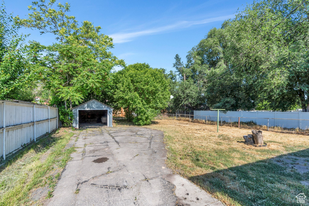 View of yard with a detached garage and an outbuilding