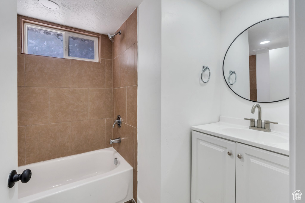 Bathroom featuring vanity, shower / tub combination, and a textured ceiling