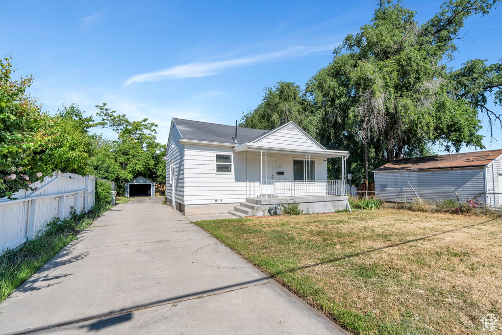 Bungalow-style house with a porch, an outdoor structure, concrete driveway, and crawl space