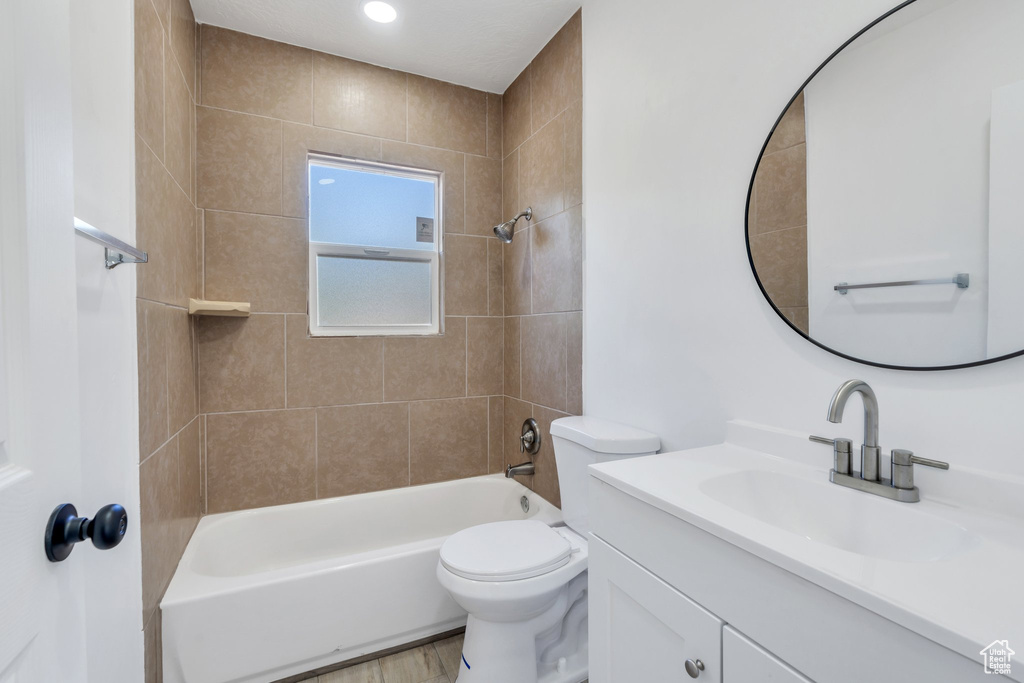 Bathroom featuring vanity, shower / washtub combination, toilet, and wood finished floors