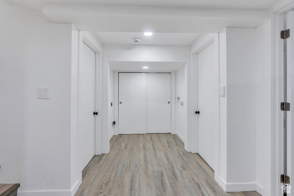Hall with light wood-style floors and baseboards