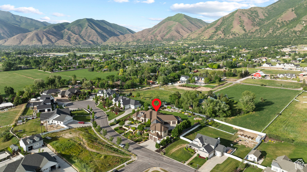 Aerial view of property and surrounding area with nearby suburban area and a mountainous background