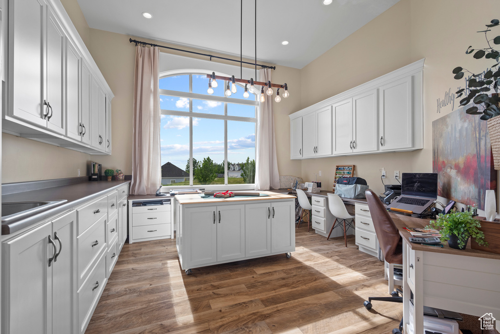 Home office with wood finished floors, recessed lighting, a sink, and a chandelier