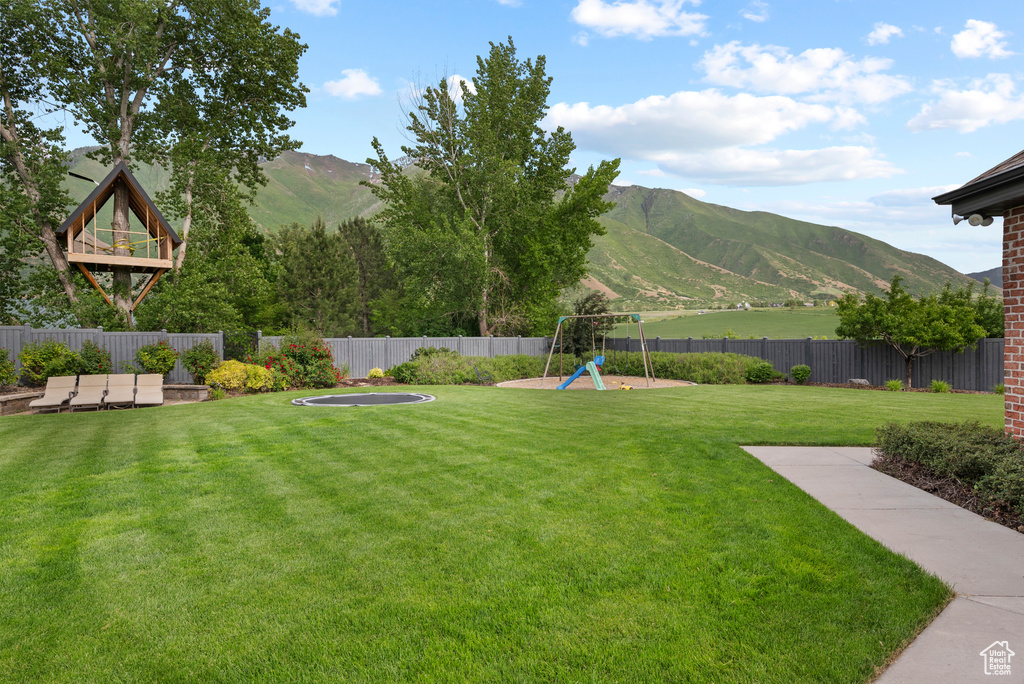 View of yard with a mountain view and a playground