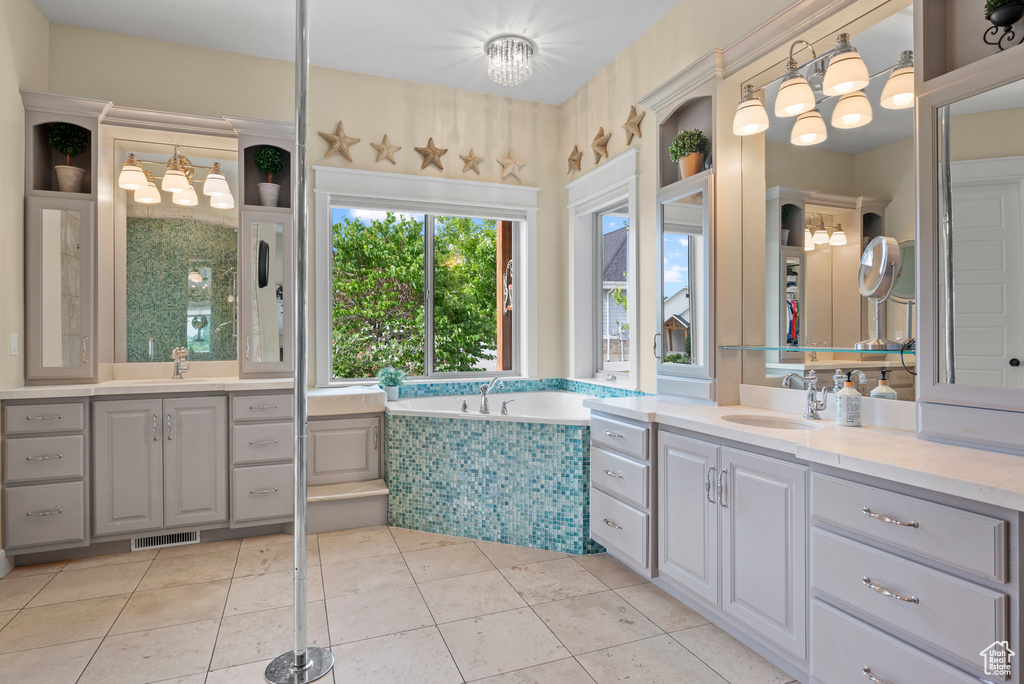 Full bathroom featuring two vanities, a bath, and tile patterned flooring