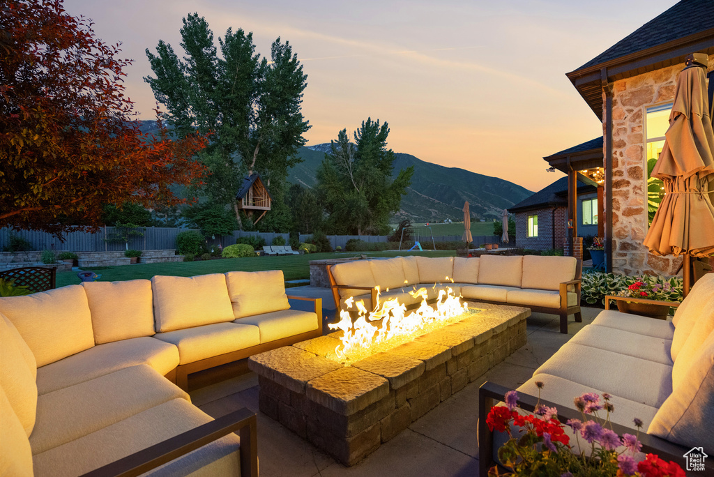 Fenced backyard with an outdoor living space with a fire pit, a mountain view, and a patio area