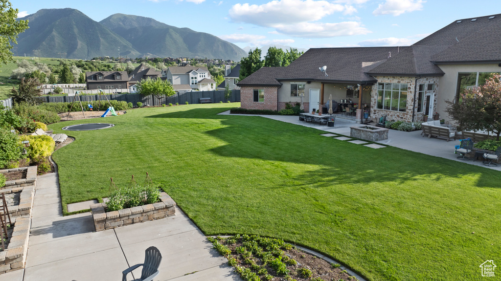 View of yard featuring an outdoor fire pit, a patio, a mountain view, and a residential view