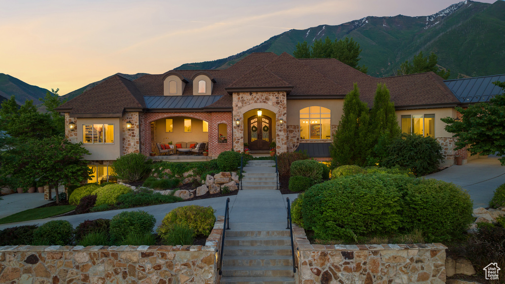 French country style house with a mountain view, stairway, and stucco siding