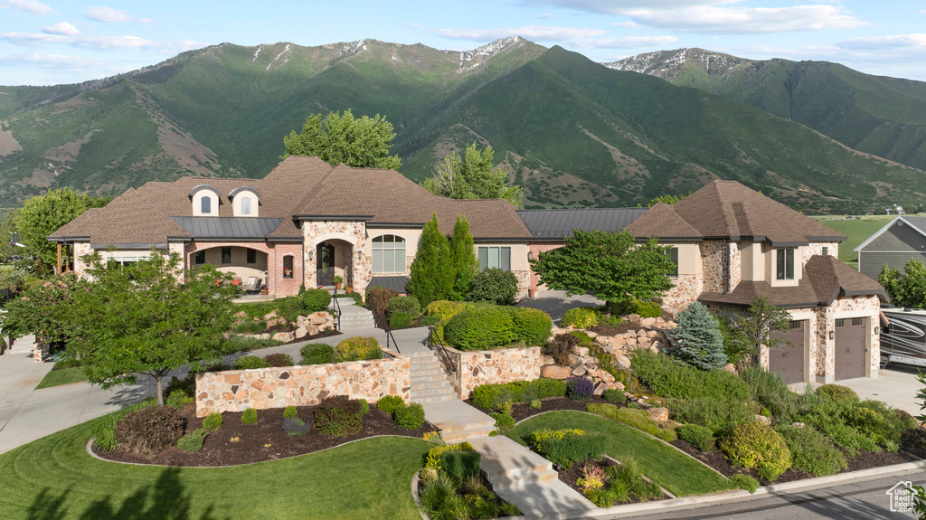View of front of house with stone siding, a mountain view, and stairs