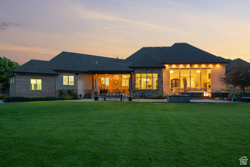 Back of property with a patio area, an outdoor living space, and a lawn