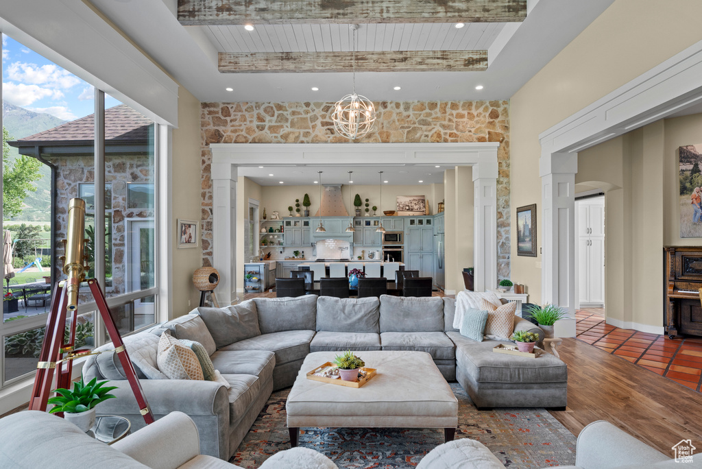 Tiled living room with a towering ceiling, recessed lighting, and a chandelier