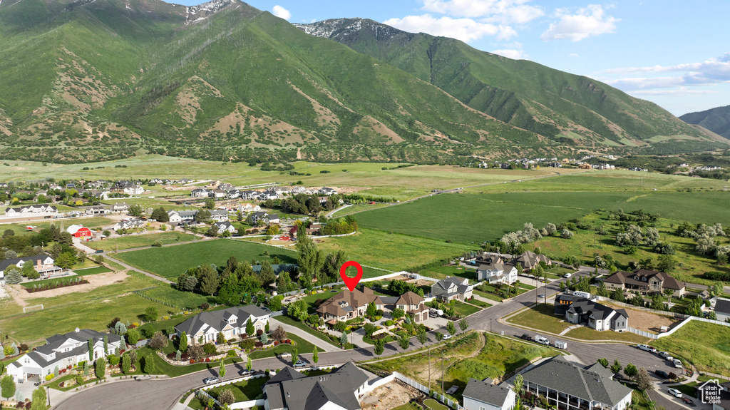 Aerial view of property and surrounding area featuring a mountainous background and nearby suburban area