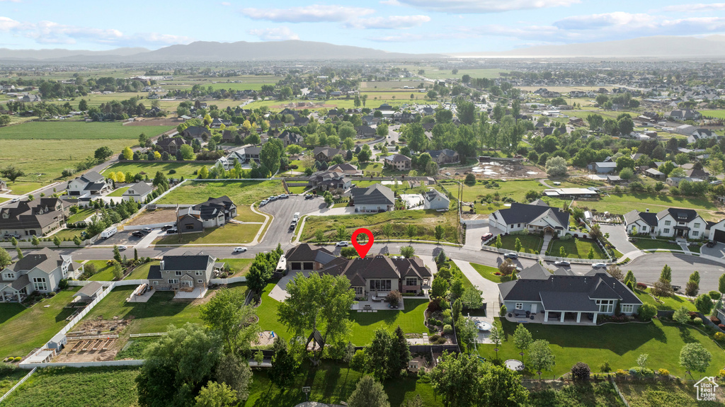 Aerial view of property and surrounding area with mountains and nearby suburban area